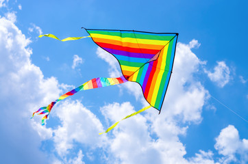 colorful flying kite flying in the sky with clouds