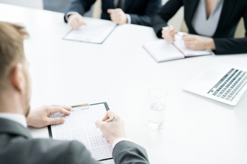 High angle shot of unrecognizable businessman marking answers in test sheet during job interview, copy space
