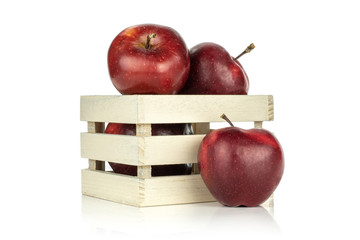 Red delicious apples in a wooden box and one is near isolated on white background.