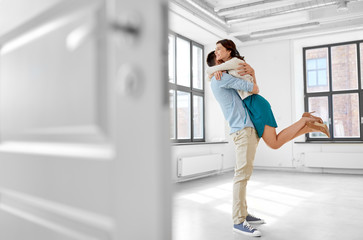 mortgage, people and real estate concept - happy couple hugging at new home