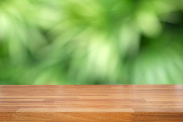 Empty wooden table and blurred green leaves  background, product display, Ready for product montage. nature garden scene