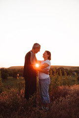 Fototapeta na wymiar Couple holding hands at sunset enjoying romance and sun.