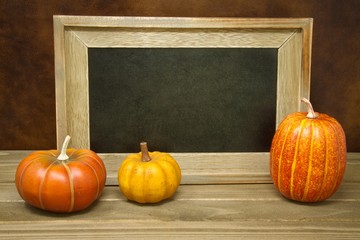 Pumpkins with an empty chalk board providing copy space.