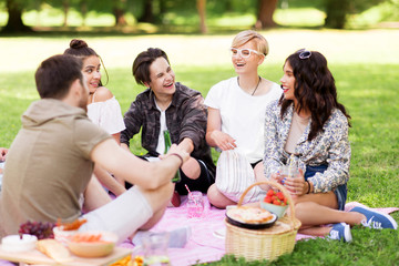 friendship and leisure concept - group of happy friends with non alcoholic drinks and food at...