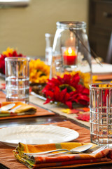 A table set for a fall feast with the focus on the foreground.