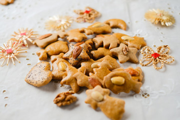 Various shapes of gingerbread on white cloth and blurry background