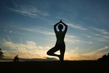 Silhouette of a young girl yoga pose sunset sport