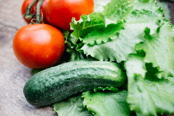 fresh vegetables, tomatoes, cucumbers, lettuce on a wooden table