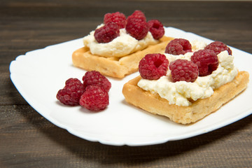 Sweet waffles with wheaped cream and raspberrries. Dessert