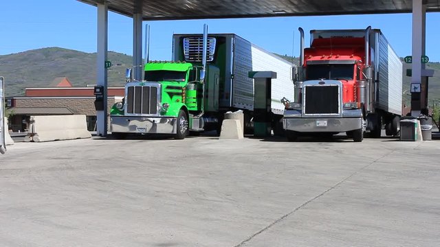 Pan Of Two Semi Trucks Refueling At A Truck Stop.