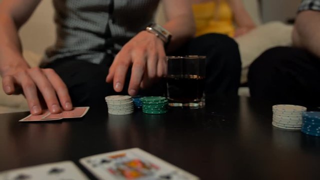Leisure, games, friendship, gambling and entertainment - Close up of hands with playing cards and chips on table.. 4k slow motion. Huge rate on river. Whiskey and cola drinks.