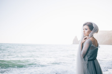 Fototapeta na wymiar Horizontal photo of a beautiful bride woman on the beach. Fine art, copy space