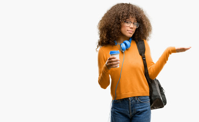 African american student woman holding something in empty hand