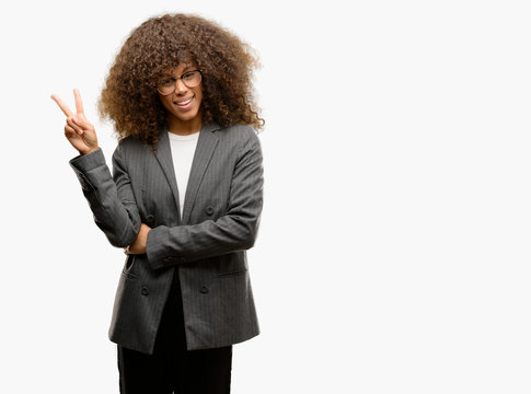 African american business woman wearing glasses smiling with happy face winking at the camera doing victory sign. Number two.