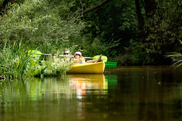 Two happy girls enjoying kayak on the river