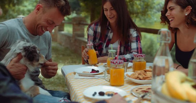 group of friends doing breakfast outdoors in a traditional countryside. shot in slow motion