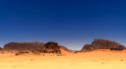 Fototapeta na wymiar View to a camp for tourists in the desert of the nature reserve of Wadi Rum, Jordan, dark blue sky above red desert
