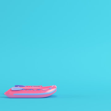 Pink inflatable boat on bright blue background in pastel colors
