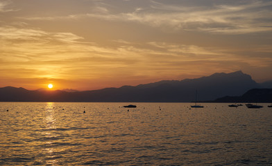 Naklejka premium Spektakularny zachód słońca z pięknym światłem w mieście Bardolino / Lake Garda we Włoszech