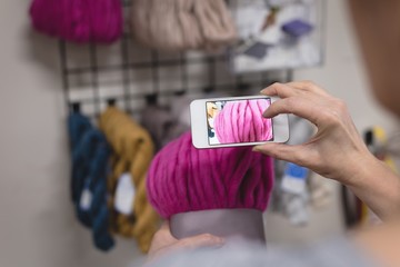 Woman taking photo of yarn with mobile phone
