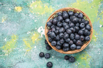 Fresh ripe blueberry  in basket, copy space on wooden board