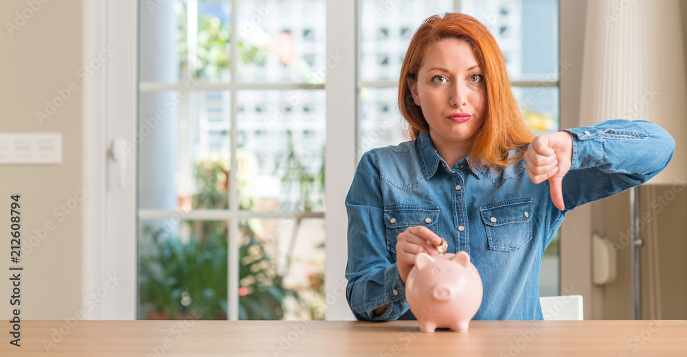 Sticker redhead woman saves money in piggy bank at home with angry face, negative sign showing dislike with 