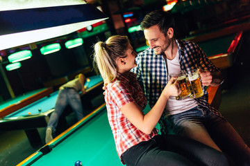 Young attractive couple on date in snooker club