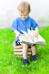 little boy with book, portrait, on the lawn