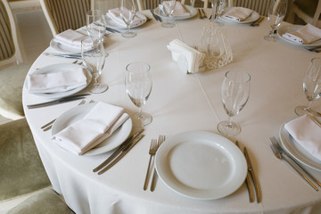Fototapeta premium The round table is covered with a white tablecloth