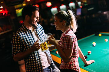 Young attractive couple on date in snooker club