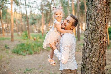 Happy father and child spending time outdoors in park. Loving child. A caring man and his infant kid kindly. Happy Fatherhood concept. Outdoor games. Forest study.