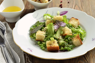 Fresh salad with lettuce, green peas, cucumber and croutons