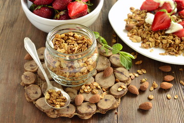 Homemade muesli in a glass jar, fresh strawberry and almonds