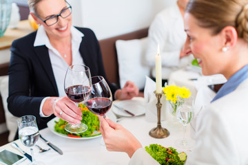 Women on business lunch toasting with wine to celebrate an agreement