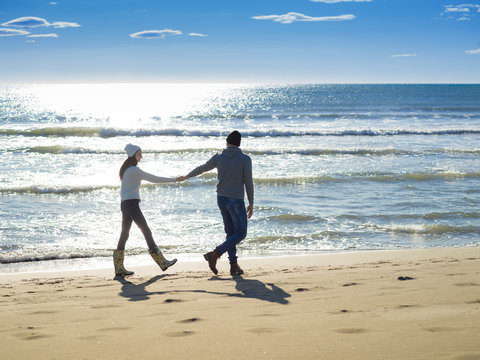 Loving young couple on a beach at autumn sunny day