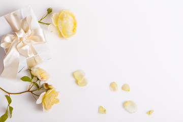Festive flower yellow English rose and gift box with ribbon composition on white background. Overhead top view, flat lay. Copy space. Birthday, Mother's, Valentines, Women's, Wedding Day concept.