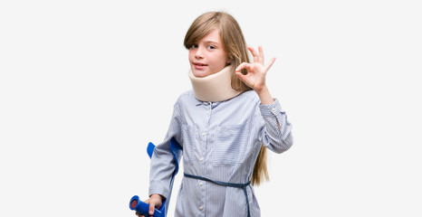 Young blonde child injured wearing neck collar and crutches doing ok sign with fingers, excellent symbol