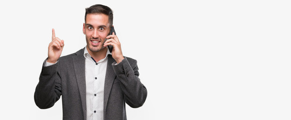 Handsome young man using smartphone surprised with an idea or question pointing finger with happy...
