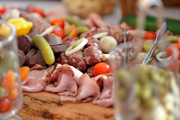 Lots of different types of meat and sausages on a wooden table
