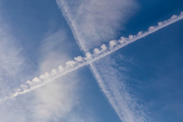 Inversion traces from aircraft. Cross in the sky. 
