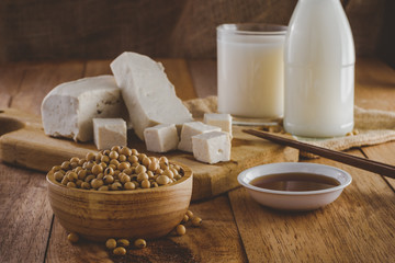 Close up of soybeans in wooden bowl. Soy products such as, milk, tofu and sauce, vintage tone, selective focus