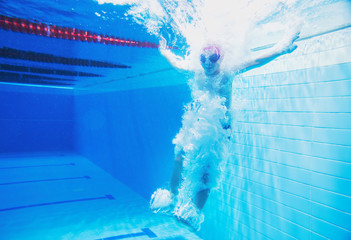 a little boy is having fun under water, tumbling and grimacing, making faces