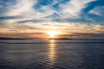 Fototapeta na wymiar sunlight rebounding from ripple sea water at sunset sunrise time