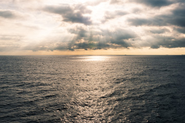 Fototapeta na wymiar sunlight come through cloud and spray at sea surface