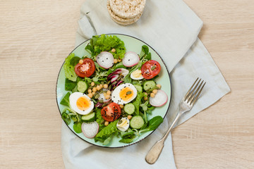 Fresh salad with vegetables and eggs for proper nutrition. Top view, copy space.