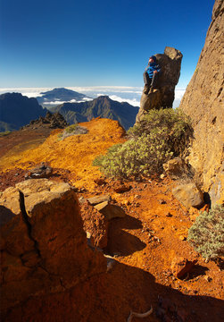 Resting man sitting on the rock above the crater Caldera de Taburiente, Island of La Palma, Canary Islands, Spain