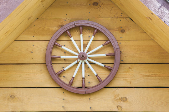 A hand-spinning wheel on the wall, half the roof