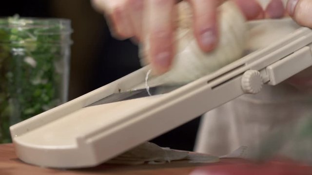 Chef slicing fresh fennel using mandolin