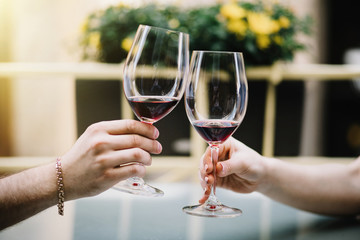 Cheerful couple in a restaurant with glasses of red wine.  Young couple with glasses of red wine in a restaurant with city view