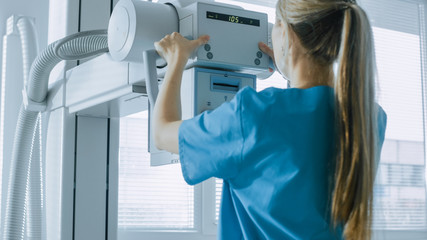 In the Hospital, Female Technician adjusts X-Ray Scanner / Machine. Modern Hospital with...